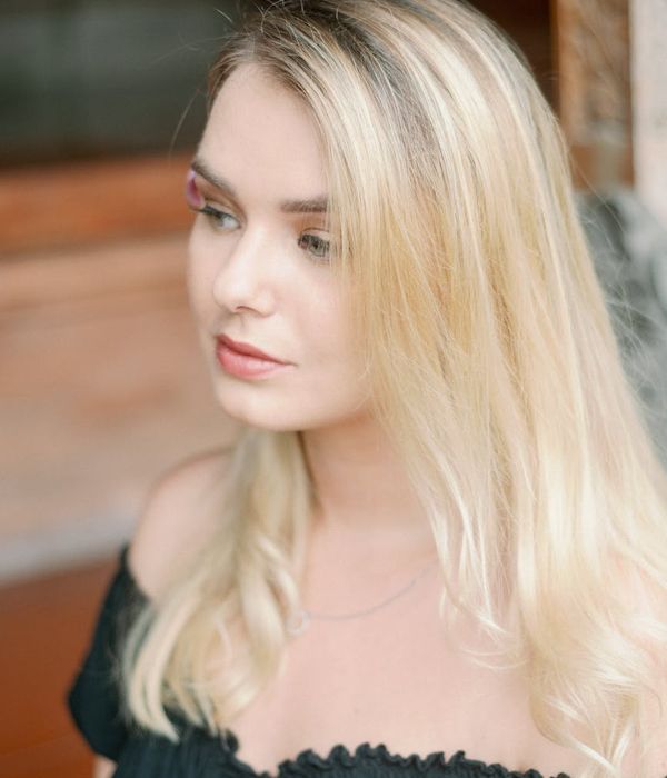 Woman with a calm and focused look, cyan light highlighting her features.